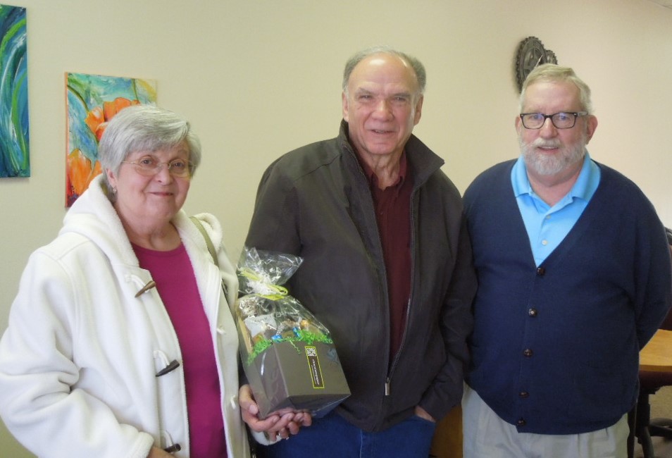 Dave and Debbie Clonch hold a gift from the New River Valley Disability Resource Center's Frank Hayes, Executive Director